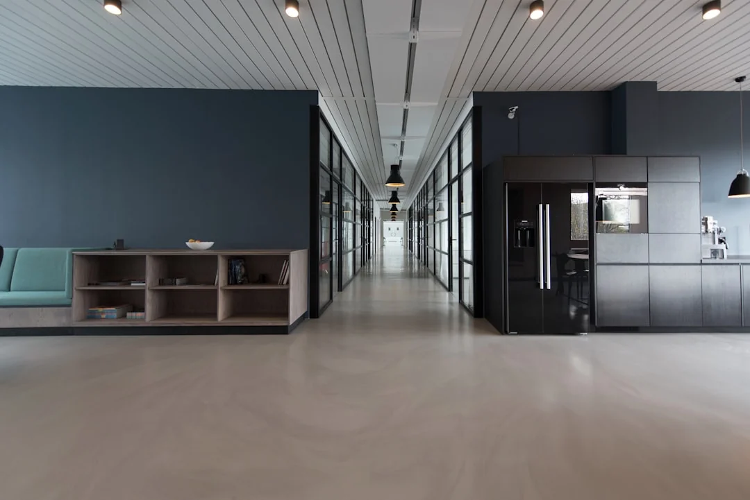 Intérieur élégant avec des cartons de déménagement étiquetés Kitchen et Office sur une table en bois entourée de plantes d’intérieur.